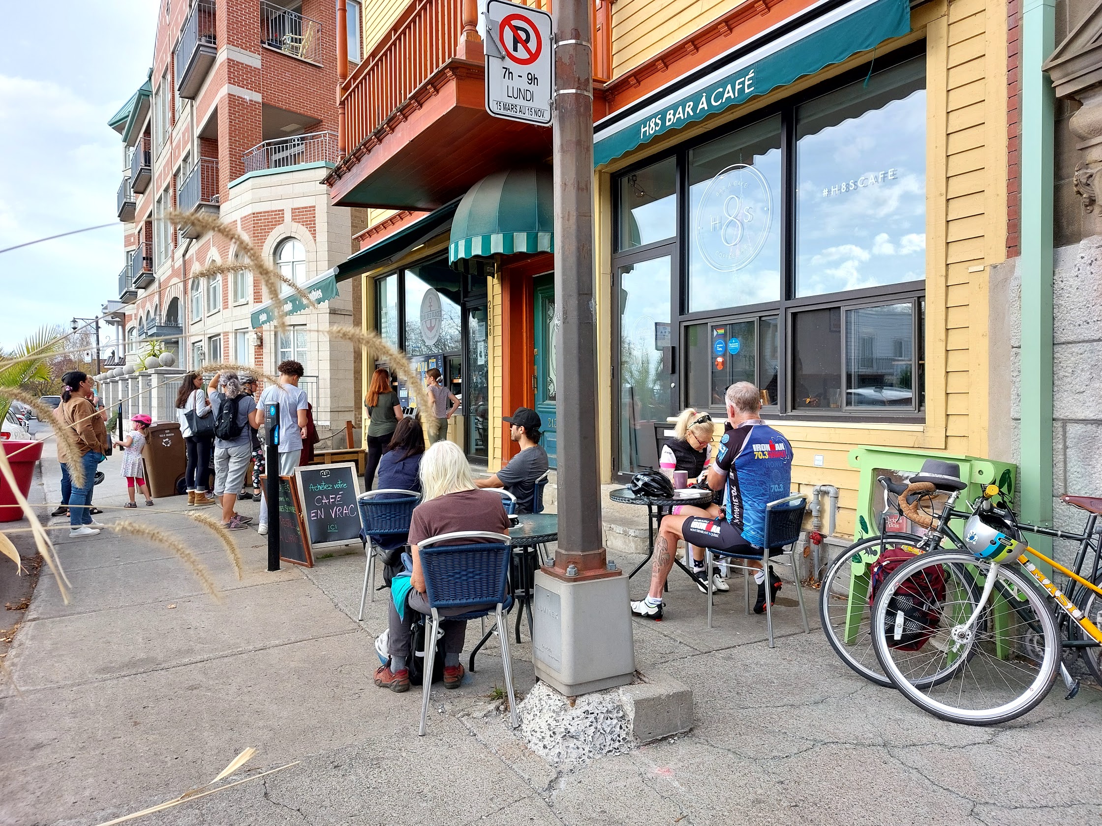 Vue d'une rue commerçante de Montréal avec clients sur une terrasse d'un bar à café